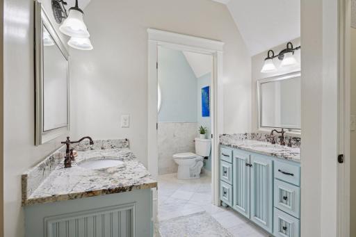 Clean and stylish upper-level bathroom with dual sinks and granite countertops.