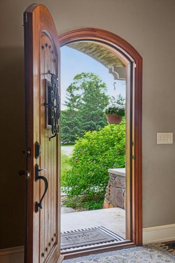 Custom arched front door and many arched windows throughout home.