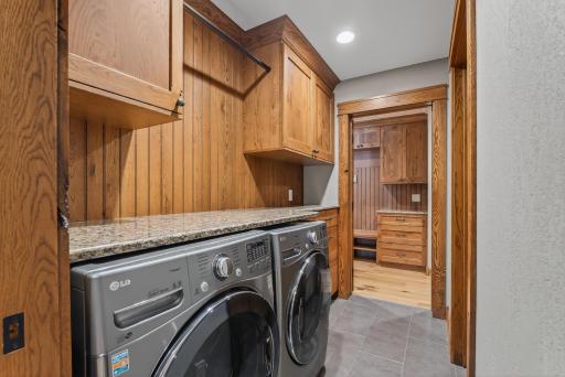 For convenience, the suite connects directly to the finished laundry room, complete with tile floors, cabinetry, countertops, and an LG washer and dryer.