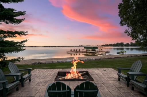 A separate patio with a built-in firepit sets the stage for cozy evenings and watching stunning sunsets over the lake.