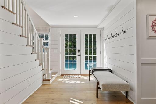 French doors lead to lower level patio, pool and grilling station