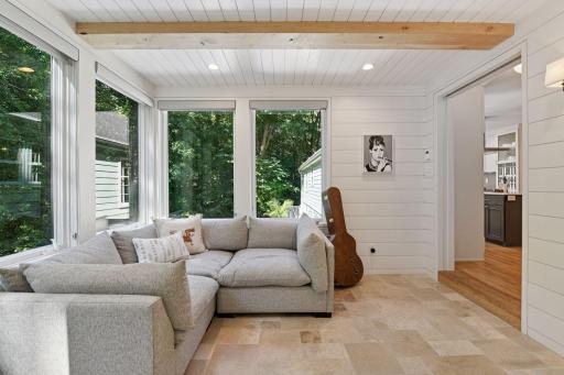 Walls of windows, heated floors and ship lap walls with wood ceiling beams; this is such a lovely spot to enjoy in all four seasons