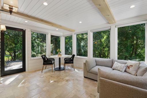 A sunfilled sunroom with heated floors and tree top views will become your favorite place to snuggle up with a book
