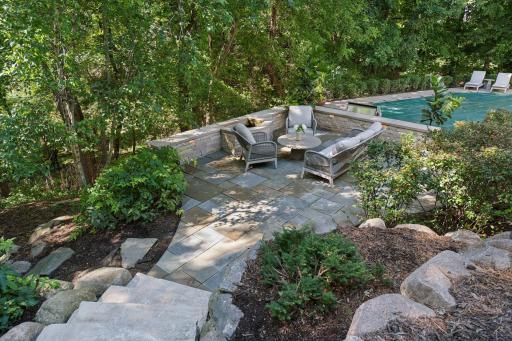 stone steps lead to the tiered patio with firepit
