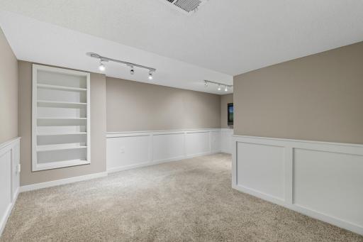Spacious finished lower level. Mounted TV remains with the home. TV is in front of a window in case you want to put a bedroom in the lower level.