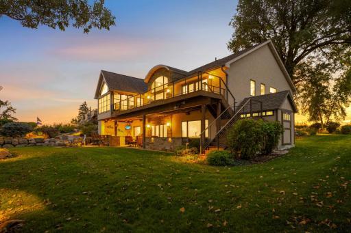 Complete lakeside living, featuring a large Ipe wood deck with stairs to the flat yard, a 10x10 Tuff Shed, outdoor kitchen, hot tub, and multiple gathering spaces.