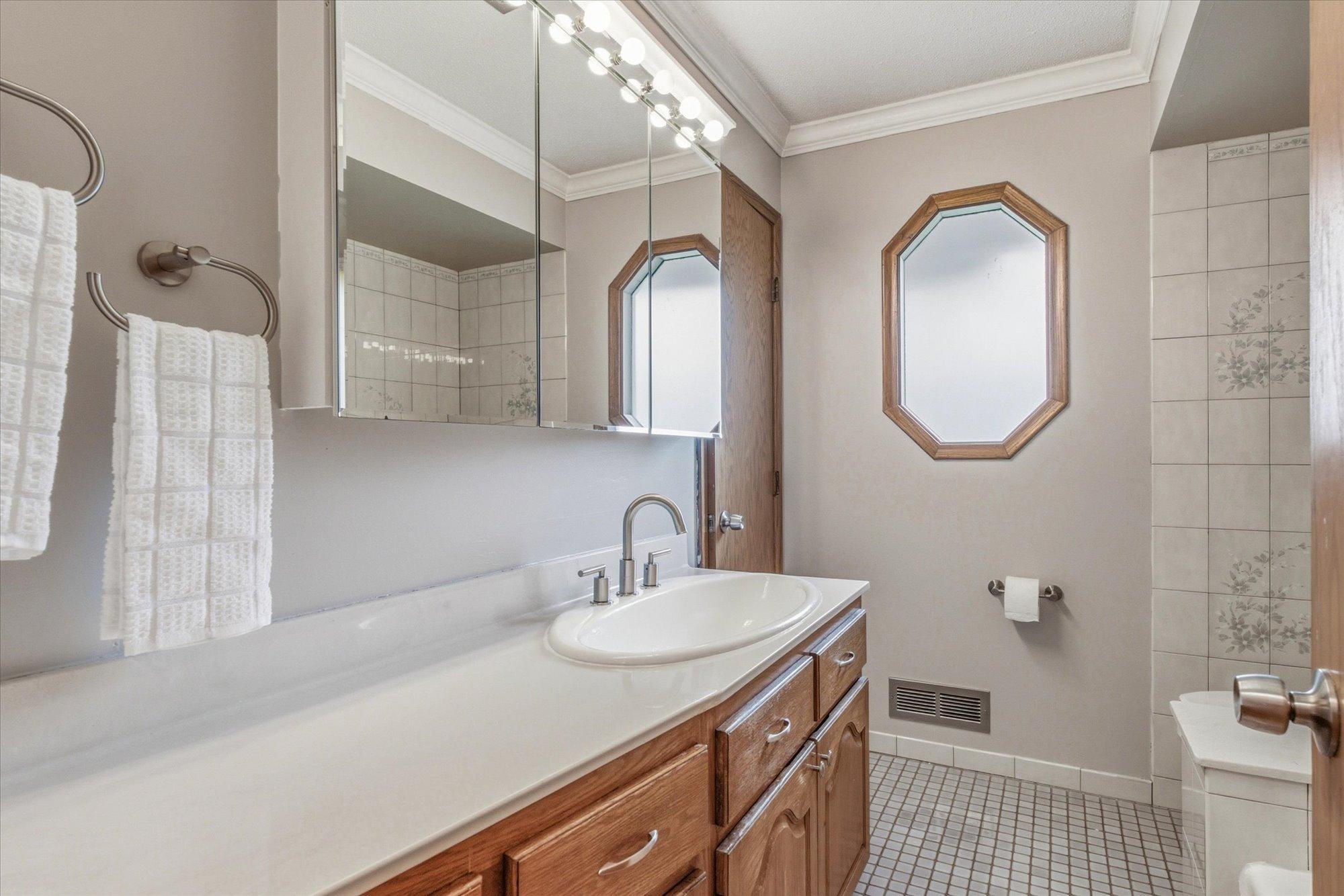 The spacious main bathroom features a large vanity with abundant storage.