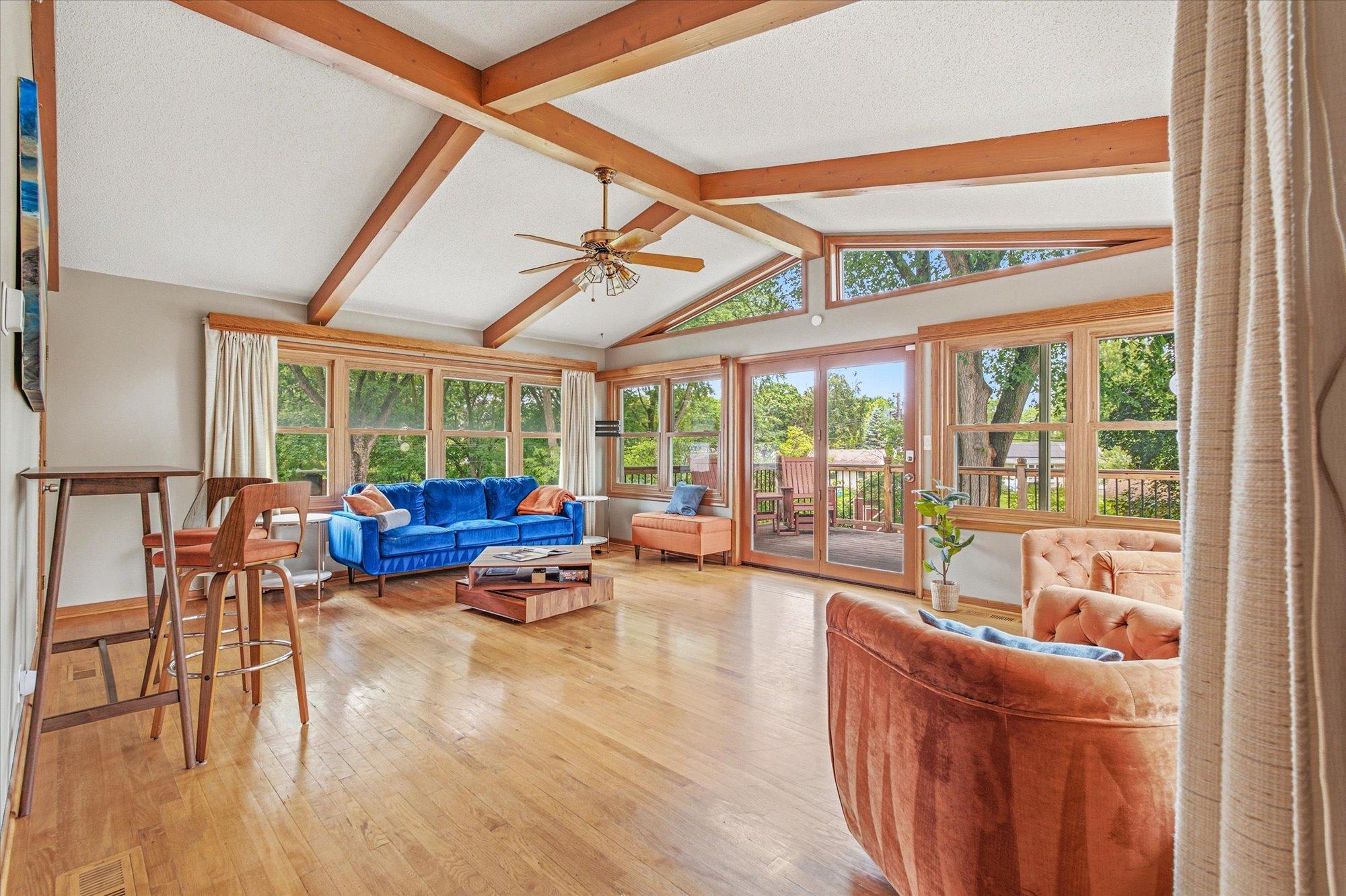 The vaulted great room showcases beautiful wood beams and walls of windows.