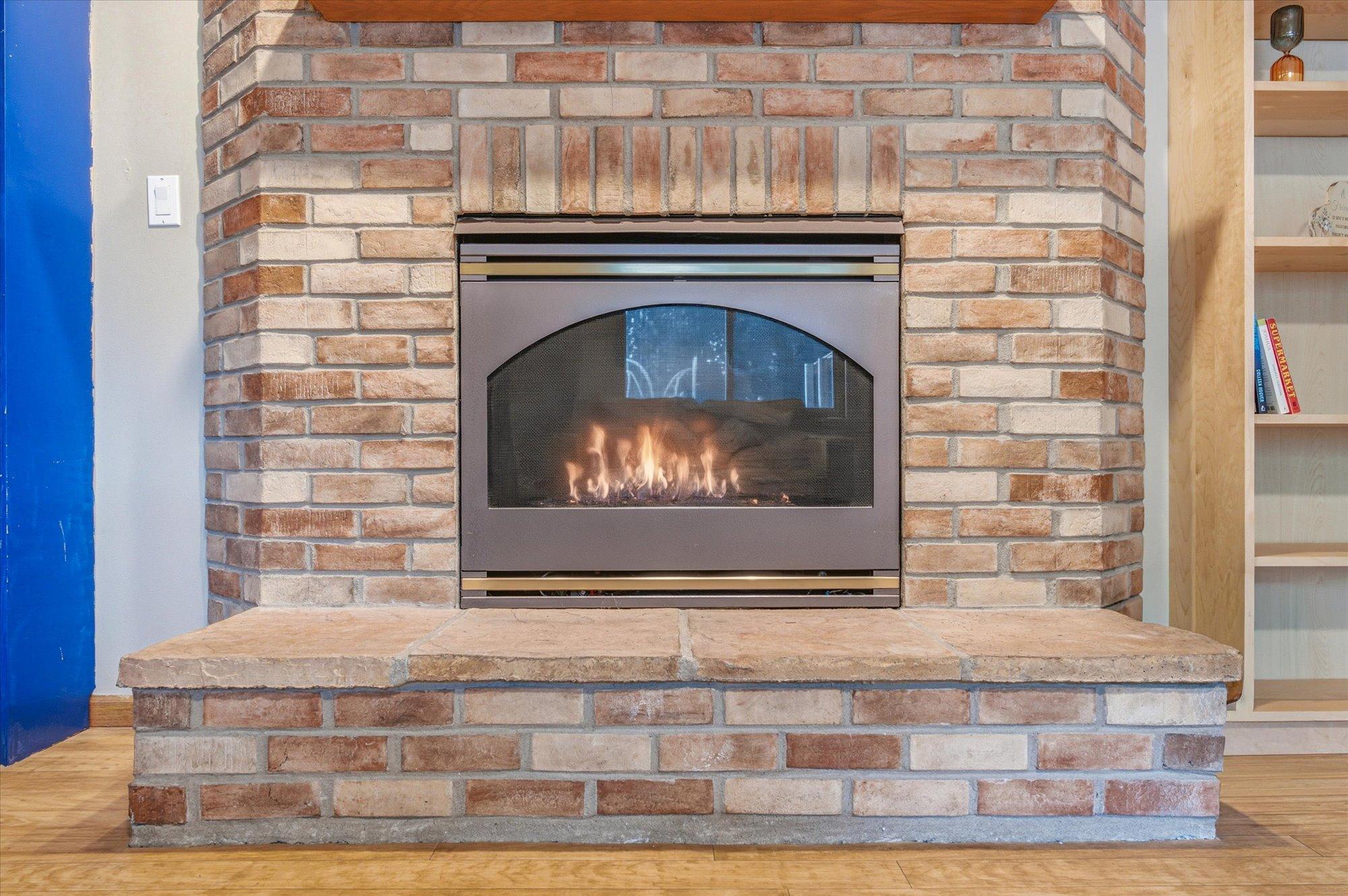 Gather around the cozy brick fireplace in the expansive lower-level living area.