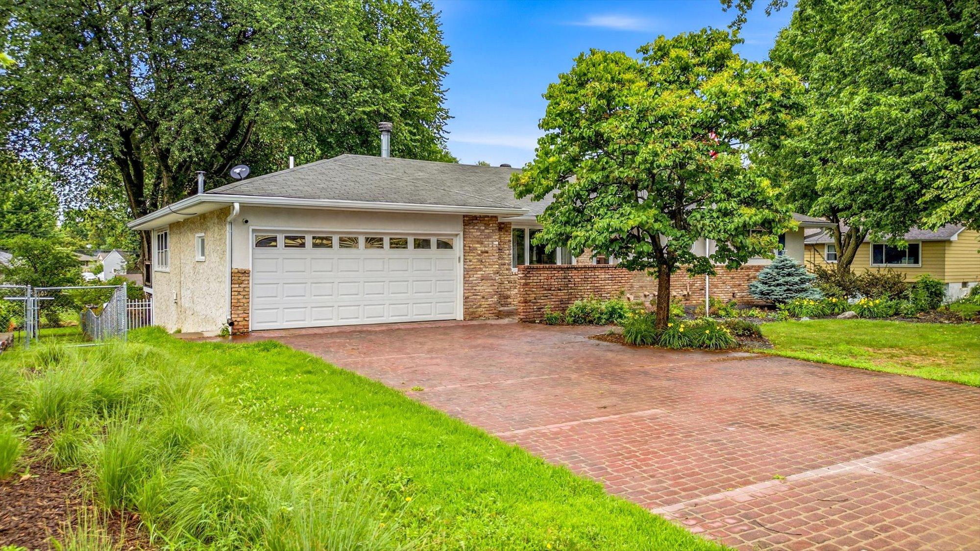 The oversized driveway and mature landscaping create welcoming curb appeal.