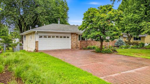 The oversized driveway and mature landscaping create welcoming curb appeal.