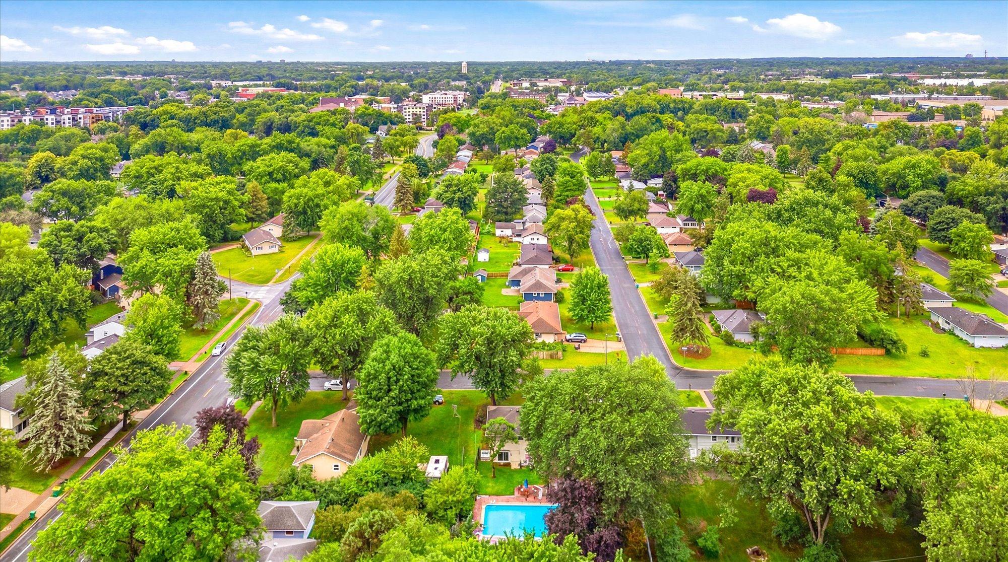 Aerial views highlight the surrounding parks, trees, and neighborhood.