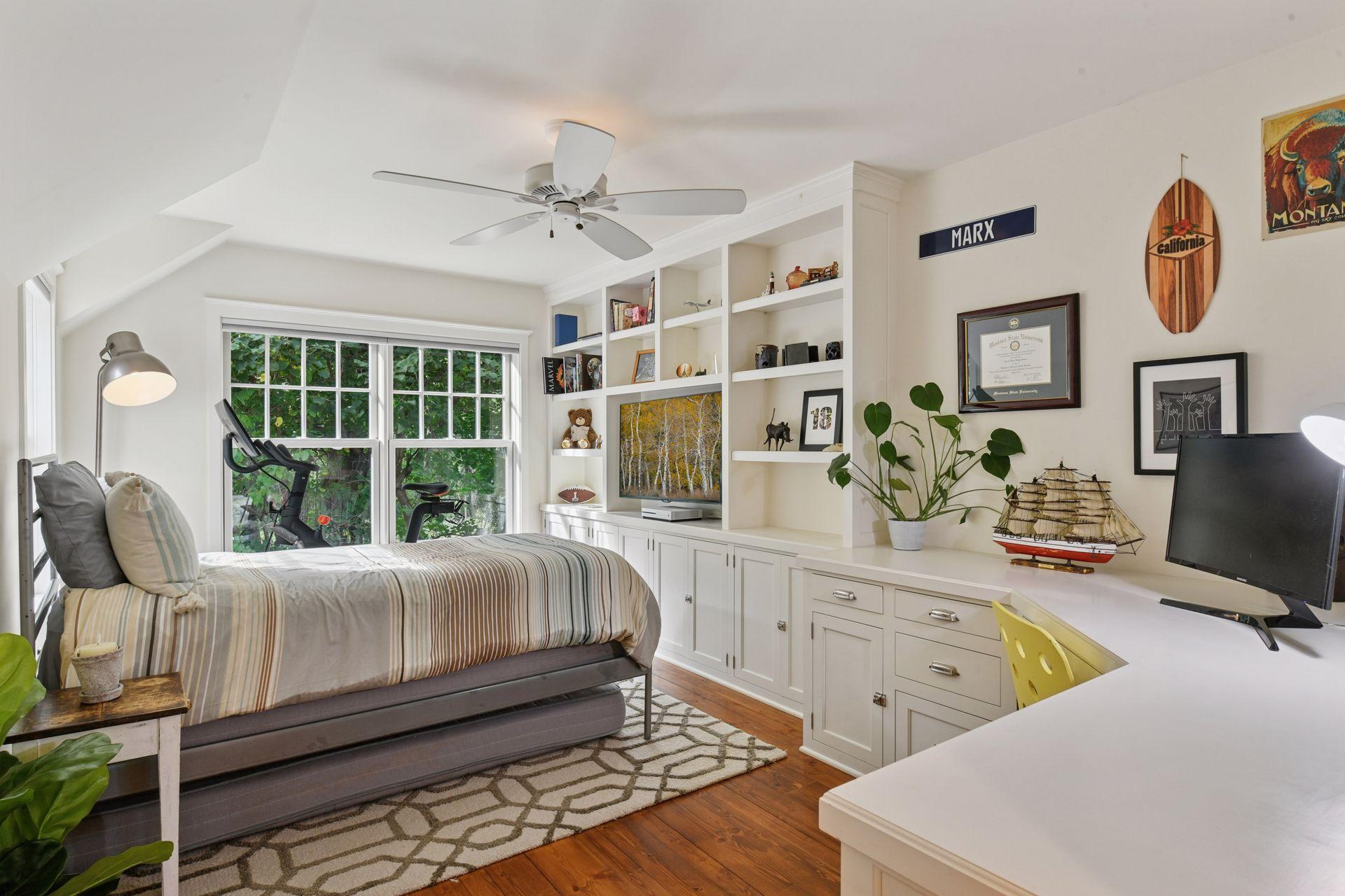 The first Junior Bedroom on the upper level features a wall of built-in cabinets, bookcases and a desk. The room also offers a walk-in closet for additional storage.