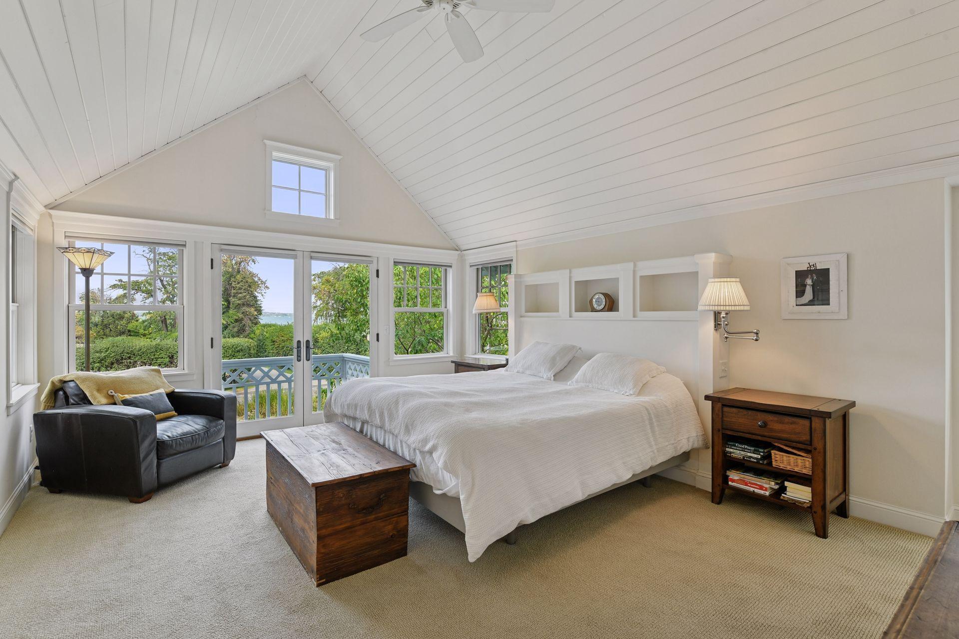 A true oasis, the Primary Suite enjoys a vaulted ceiling and large windows that look out to the sparkling waters of Lake Minnetonka.