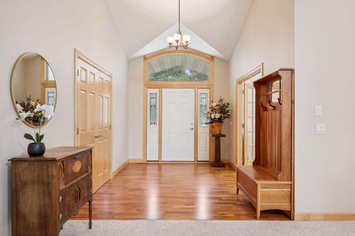 As you enter, you are greeted by soaring ceilings and gleaming hardwood floors.