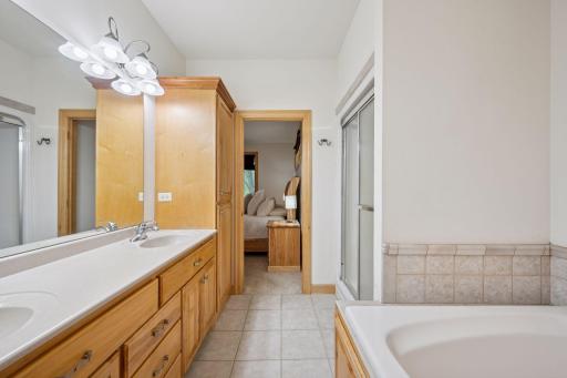 The primary bathroom features a separate shower, whirlpool tub, double vanity and ample storage space.