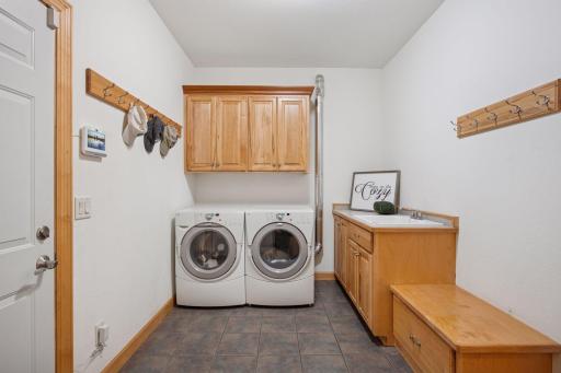 Spacious and organized laundry/mud room has plenty of storage with built in cabinetry.