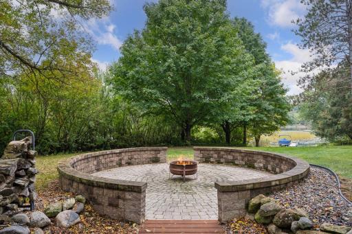 The oversized patio fire-pit area is steps away from the water and is surrounded by a large backyard.
