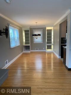 Dining room with backlit built-in cabinets and designer chandelier