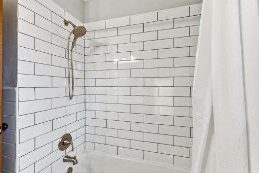 Tiled shower surround with a simple, timeless design and updated fixtures.