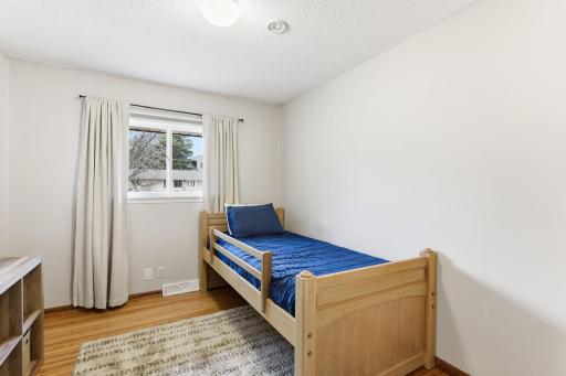 Additional bedroom with natural light, hardwood floors, and a clean, versatile layout.