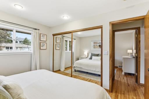 Additional view of the primary bedroom highlighting mirrored closet doors and functional storage.