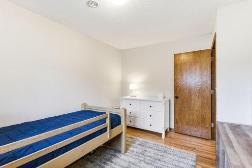 Additional bedroom with natural light, hardwood floors, and a clean, versatile layout.