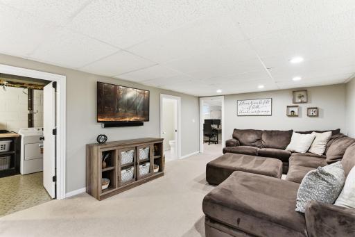 Lower-level living space with room to spread out, featuring recessed lighting and easy access to additional rooms and storage areas.