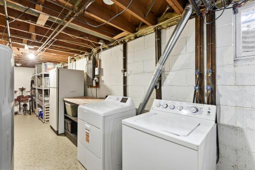 Lower level laundry and utility area with dedicated workspace and room for additional storage.