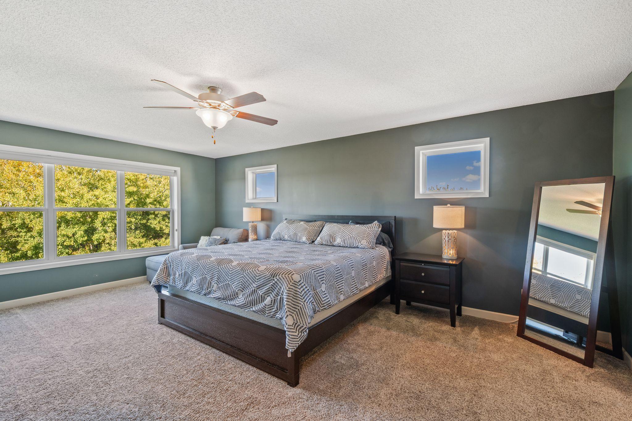The upper level MASSIVE primary bedroom boasts gorgeous backyard views!