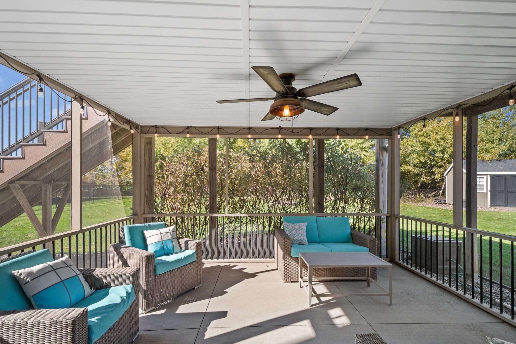 A screened in porch with lighting and a ceiling fan provide protection from the outdoors while still enjoying the sights + sounds.