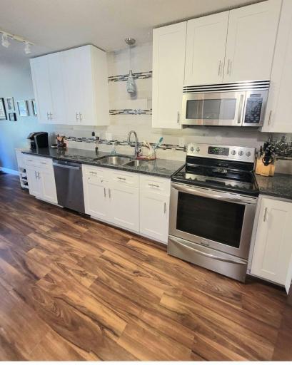 Completely updated kitchen complete with stunning tilework, solid surface counters, and soft close cabinets to the ceiling