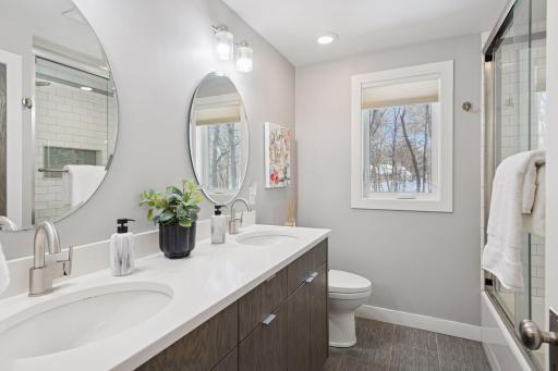 Upper level full bathroom with double sinks, tub and shower.