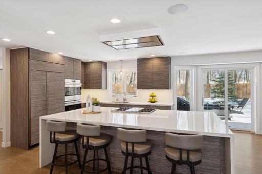 Sunlit kitchen with Quartzite counters offers nice access to the backyard.