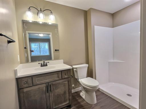 The private bath in the primary bedroom will include a walk in shower, custom vanity and upgraded countertop. Photo is from a previous model.