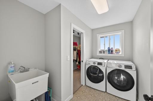 Walk through to the upper level laundry room with a sink