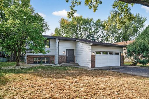 Welcoming front exterior on freshly seeded lawn with newly painted siding and new garage door.