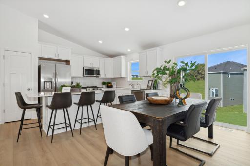 (Photo of a model home, actual finishes may vary) Enjoy plenty of seating at the kitchen island and dining area adjacent to the kitchen. Perfect for entertaining or having a family meal together.