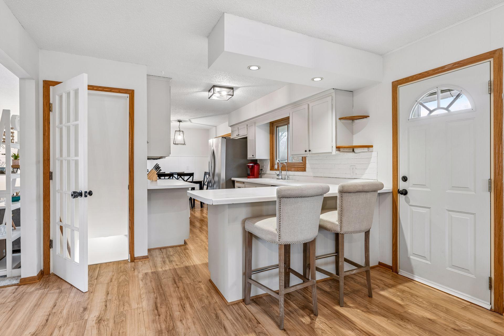 Crisp and clean kitchen with breakfast bar, stainless appliances and luxury vinyl plank flooring.