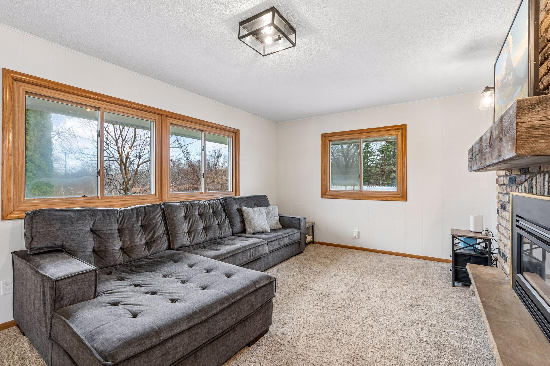 Warm and inviting main level family room with full brick accent wall featuring a gas burning fireplace with new remote.