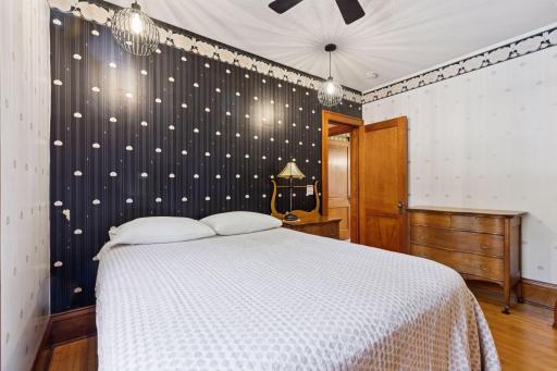 Main floor bedroom has new lighting, maple floors and fun Art Deco wallpaper.