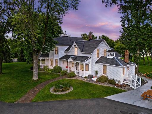 Charming 1884 Victorian farmhouse set aglow at dusk—rich in character and timeless appeal.
