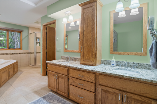 Large primary bath with jetted tub and double vanity + wall in shower.