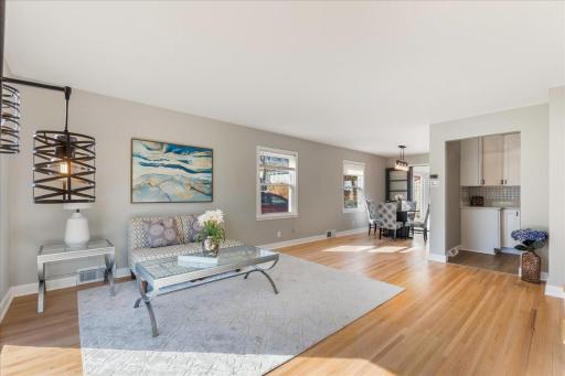 Relish in the airy expanse of our living room, bathed in natural light and adorned with beautifully refinished hardwood floors, inviting you to unwind in style.