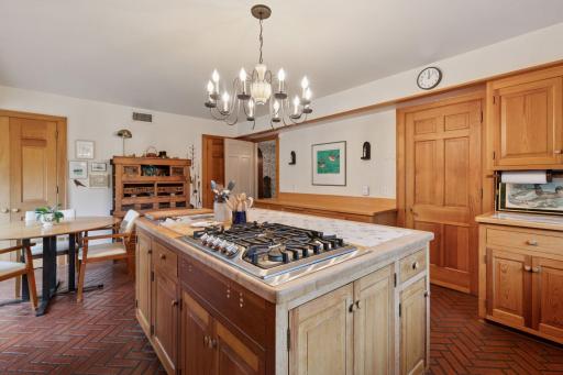 Beyond the center island, you will see the butcher-block countertop over extra cabinets.
