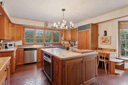Large center island with period tile countertop houses the cooktop, griddle and oven, along with storage for pots and pans.