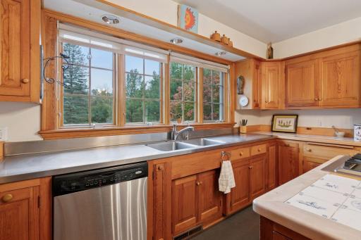 Stainless countertops on this wall where your bright kitchen windows overlook the gorgeous back acres