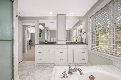 Primary en-suite features an expansive vanity, a soaking tub, and a walk-in shower, the space is crafted for both daily comfort and moments of relaxation.