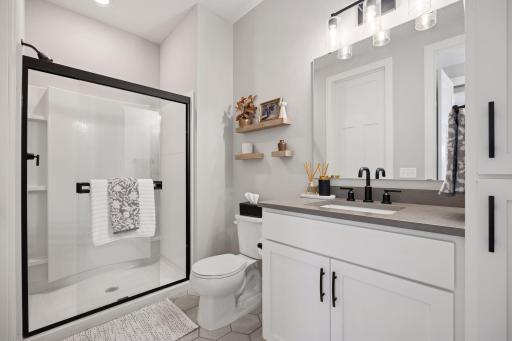 This updated Â¾ bath features a sleek sliding glass shower door and stylish tile flooring for a modern touch
