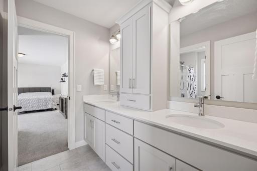 The full guest bathroom offers comfort and convenience with dual sinks and abundant storage